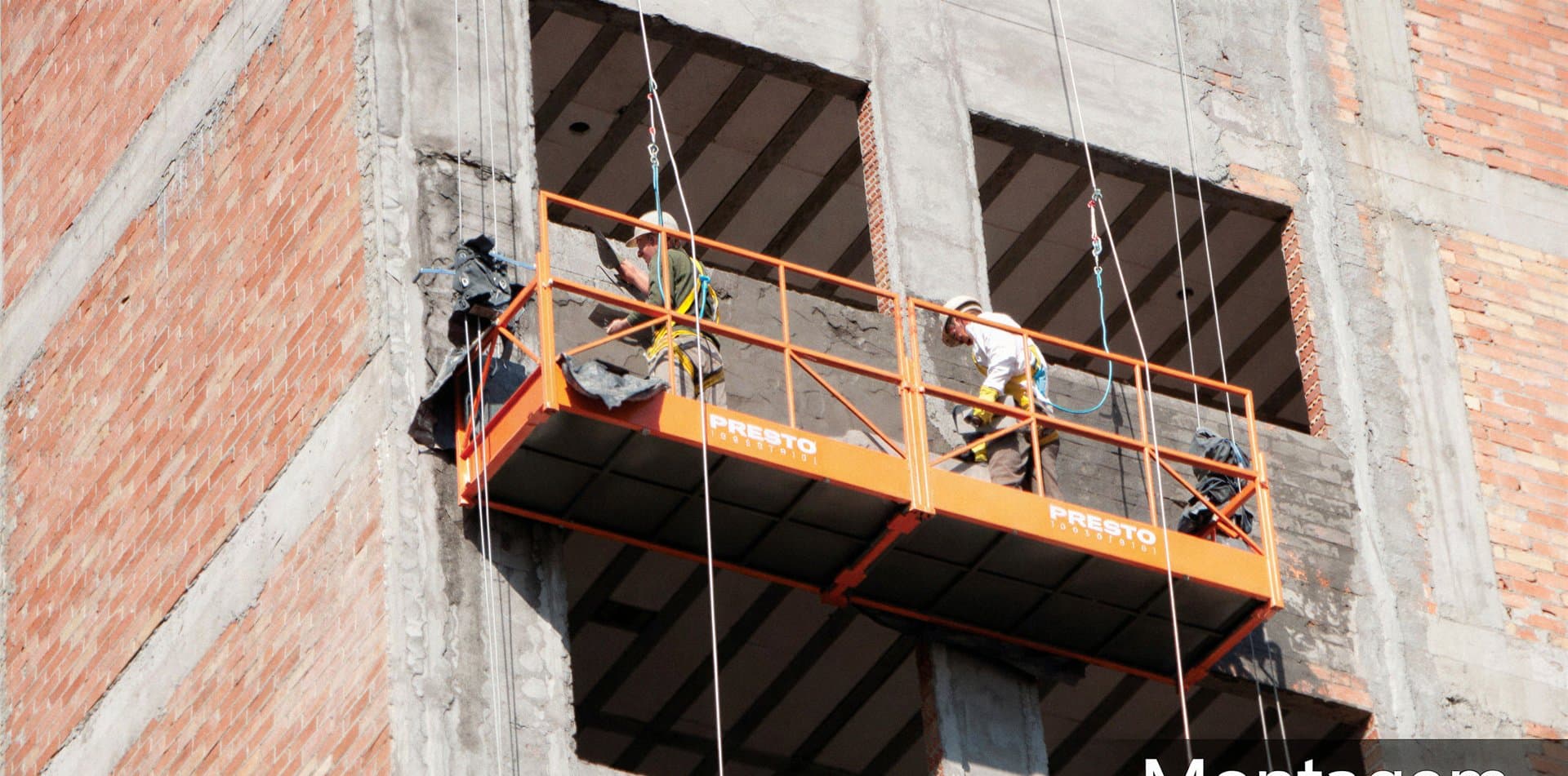 Equipe trabalhando em andaime suspenso instalado pela 4M Engenharia na fachada de um edifício em obras